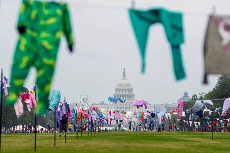 Washington DC, USA - June 9, 2019: Family Separation Protests. Symbolic washing cords with a small children's clothes next to the Capitol building.のeditorial素材