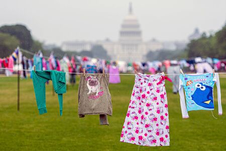 Washington DC, USA - June 9, 2019: Family Separation Protests. Symbolic washing cords with a small children's clothes next to the Capitol building.のeditorial素材