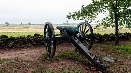 A Civil War era cannon is placed behind a stone wall in Gettysburg, PAの写真素材