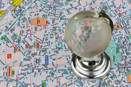 Close-up of a glass globe on a tourist map background. Selective focus on the map. The concept of ...