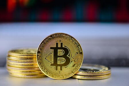 golden bitcoin on notebook keydoard with chart on background, selective focus - imageの写真素材