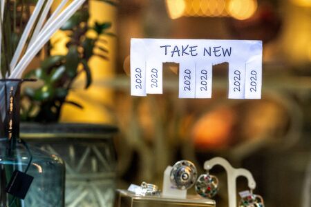 Christmas shop window with paper with the phrase: Take New and with a 2020 sign ready to be tore off - imageの写真素材