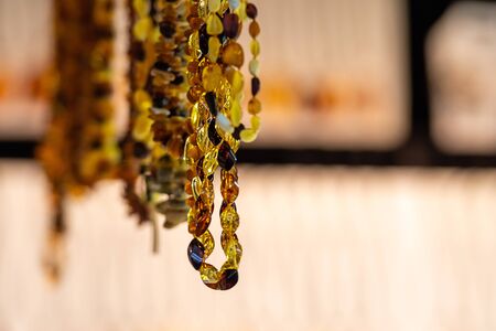 Amber background of beads and necklaces at the handicraft market. Traditional Souvenirs From Baltic Countries, selective focus - imageの写真素材