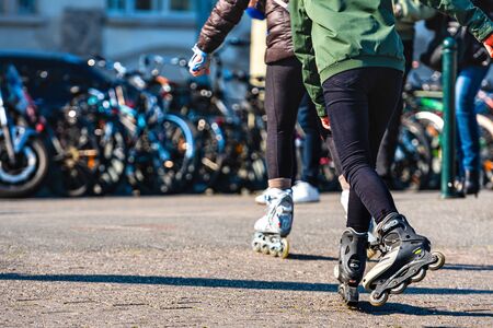Geneva, Switzerland - April 14, 2019: teenager roller skating on city street, closeup of legs -...