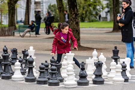 Geneva, Switzerland - April 16, 2019: People playing traditional oversized street chess in Parc des Bastions - imageのeditorial素材