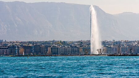 Geneva, Switzerland - April 15, 2019: Lake of Geneva with its Jet d.Eau or large fountain spraying out of the lake 140 meters or 460 feet high the cities most famous landmark - imageのeditorial素材