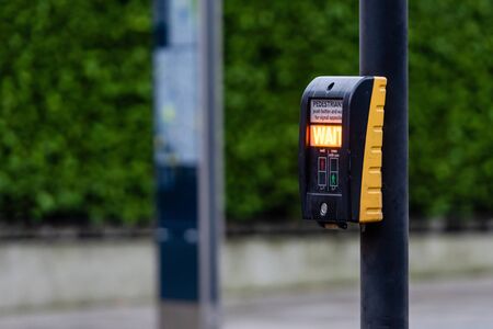 Crosswalk button for pedestrian with light warning on a defocused background , London, UK - image