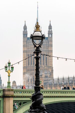 Dolphin lamp standard on Thames Embankment in London at the Westminster Bridge, bloored Westminster...
