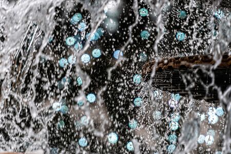 A close-up of a splash of water with a Christmas garland in a defocused background