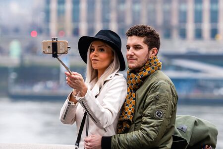 London, UK - January 1, 2020: A couple of young people take selfies with a London skyline in the backgroundのeditorial素材