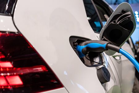 Power supply for electric car charging. Electric car charging station. Close up of the power supply plugged into an electric car being charged - imageの写真素材