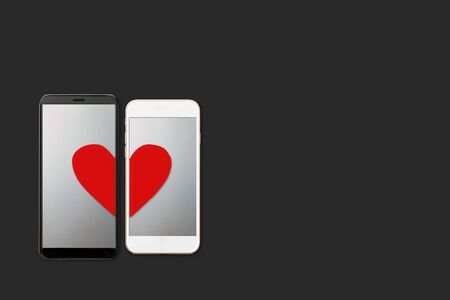Online dating concept, halves of the heart on the two mobile smartphones screens, isolated on dark backbround, flat layの写真素材