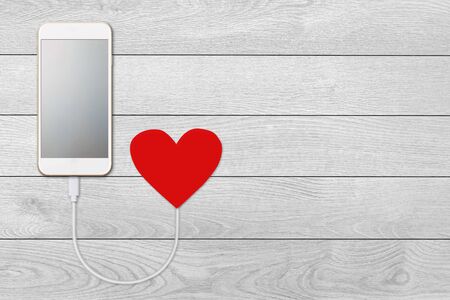 concept of the power of love, on white wooden background  isolated Mobile smart phone with blank...