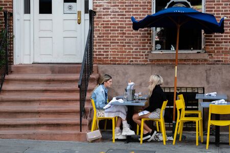 New York, USA - June 21, 2019: Two women sit in a street cafe and drink teaのeditorial素材