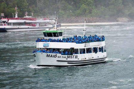 Niagara Falls, NY, USA - June 13, 2019: Ship with tourists moves to Niagara falls, Falls boat tour experience is North America oldest attraction, and has drawn millions of visitors since 1846のeditorial素材