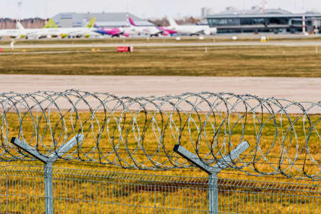 Riga, Latvia - April 17, 2020: coronavirus pandemic quarantine, flights canceled, behind a barbed wire fence visible aircraft, parked for a long time at Riga International Airport, selective focusのeditorial素材
