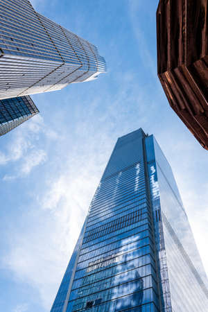 New York, USA - June 8, 2019: Low angle graphic view of skyscrapers and the Vessel building parts, sunny blue sky, New York City - Imageのeditorial素材