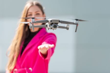 drone lands on hand, defocused young woman in the background, focus on the quadcopter