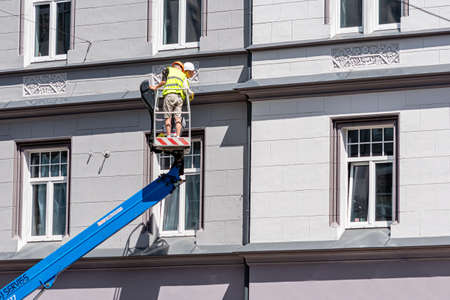 Riga, Latvia- July 3, 2020: construction worker on a hydraulic lift platform inspect the condition of sewage pipesのeditorial素材