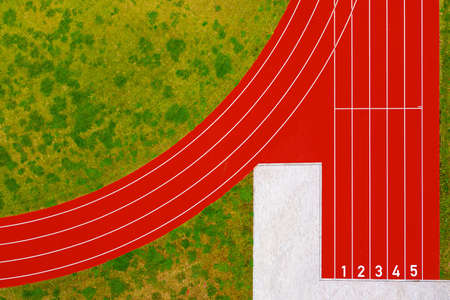 top down view of red running tracks start with numbers and green grass lawn, red running track at...