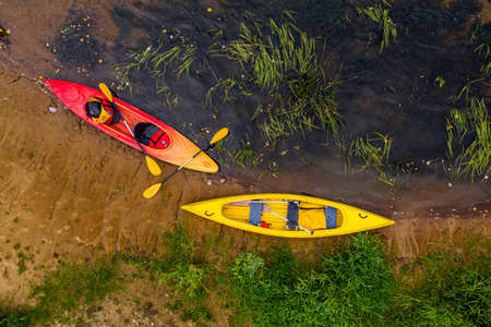 multicolored empty kayaks and canoes on the river bank, top down viewの写真素材