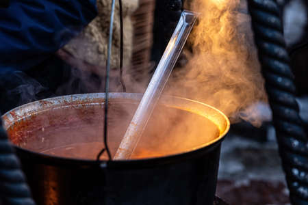 large metal soup pot on an open fire at an outdoor Christmas market, street food, close-upの写真素材