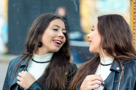 a young, attractive woman makes various grimaces and enjoys her reflection in the mirrorの写真素材