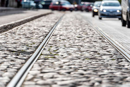 Cobblestone street with tram rail tracks in Riga, Latvia, blurred traffic in backgroundの写真素材