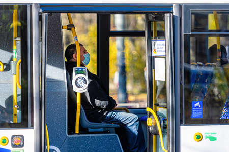 Riga, Latvia - November 6, 2020: people with medical masks on their faces in the public transport, coronavirus protection conceptのeditorial素材