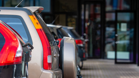 a row of cars in the parking lot outside the office building, close-up