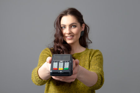 woman holding wireless modern bank payment terminal to process and acquire credit card payments