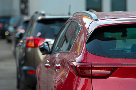 rows of different cars parked along the roadside in crowded city, close-up, selective focusの写真素材