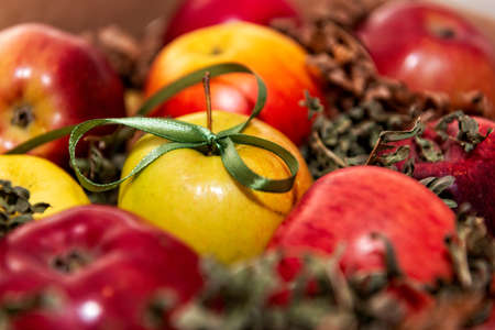 red, tasty apples closeup on a background of green moss, gift decoration with green ribbon