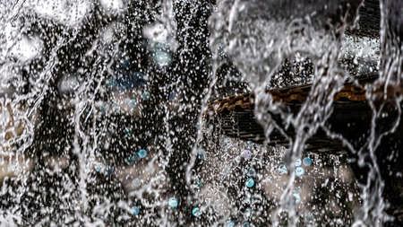 A close-up of a splash of water with a Christmas garland in a defocused background