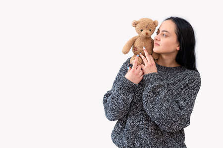 young female holding teddy bear, isolated on white backgroundの写真素材
