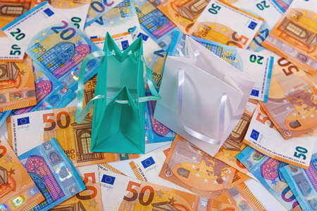 close-up of colorful shopping bags on euro banknotes, commerce and sale concept