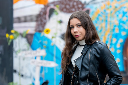positive young girl portrait on blurred wall sprayed with graffiti