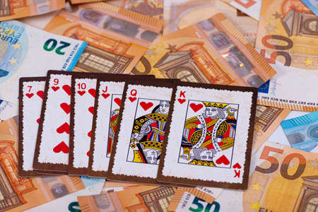 playing cards against the background of euro banknotes, gambling concept, close-upのeditorial素材
