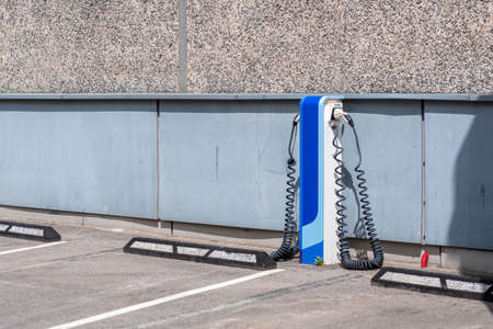 charging station terminal for electric car with power cable supply in an outdoor parking lotの写真素材