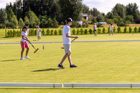 Ikskile, Latvia - July 4, 2021: a group of people playing croquet on the lawn, family activity conceptのeditorial素材