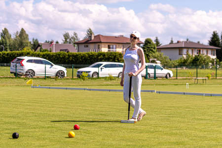 Ikskile, Latvia - July 4, 2021: a young woman playing croquet on the lawn, family activity conceptのeditorial素材