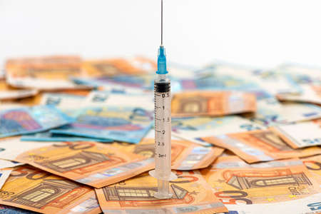 Close-up syringe and euros banknotes bills. Cost of health, medicine, drug conceptの写真素材