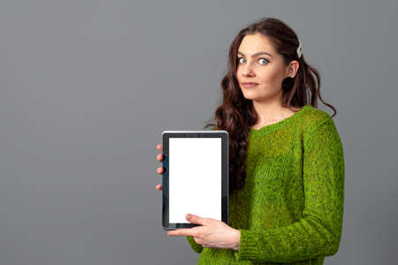 emotional young woman showing tablet computer with empty touch screen with copy space, isolated on...
