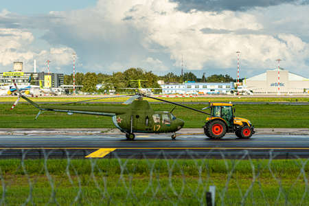 Riga, Latvia - August 19, 2021: the tractor towing old military helicopter (aviation museum exhibit) through the airport territoryのeditorial素材