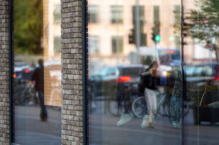 urban background with large shop windows reflecting the street with people and traffic, closeupの写真素材