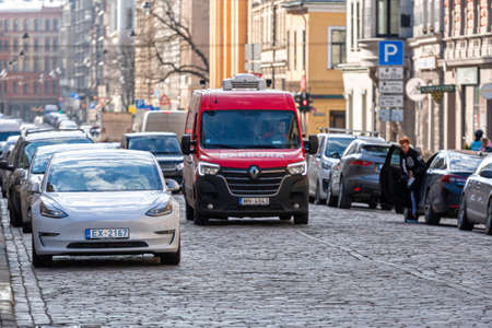 Riga, Latvia - 7 April, 2021: white Tesla model 3 car parked on urban roadside in Riga, front viewのeditorial素材