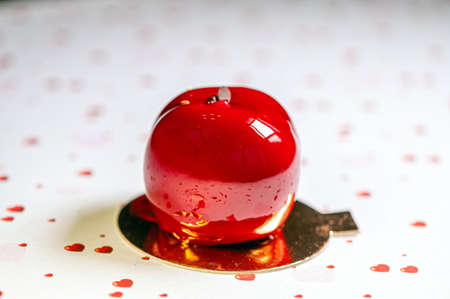 homemade apple-shaped cream cake with icing on a white background with hearts, closeupの写真素材