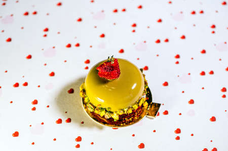 home-baked avocado cake with icing, sweet cream and nuts on a white background with hearts, closeup
