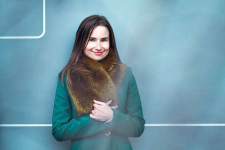 closeup portrait of an elegantly dressed business woman near a blue wall of a modern office buildingの写真素材