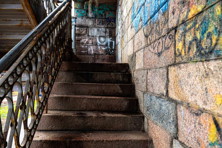 Riga, Latvia, November 2, 2021: old stone stairs for boarding the bridge, walls with graffiti, stone textureのeditorial素材